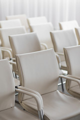 background of row of white seats. Empty hairs in the conference hall.