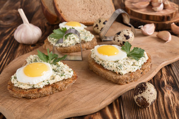a sandwich in the shape of a heart with egg, cheese, dill, garlic on a wooden table