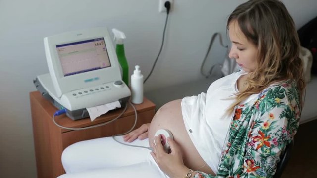 Woman during foetal heart monitor during check.
