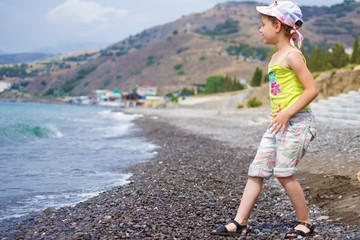  A child walks along the rocky sea beaches.
