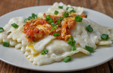 Ravioli with tomato sauce on a wooden background