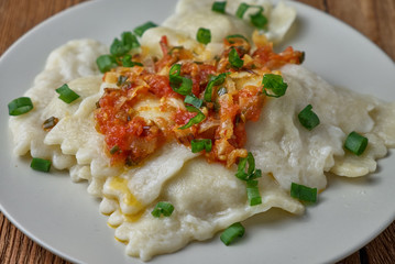 Ravioli with tomato sauce on a wooden background