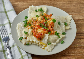 Ravioli with tomato sauce on a wooden background