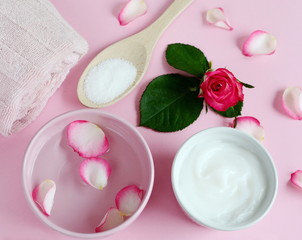 Obraz na płótnie Canvas Cosmetic creams and bath towel with pink flowers