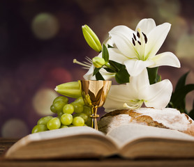 Symbol christianity religion a golden chalice with grapes and bread wafers and flower