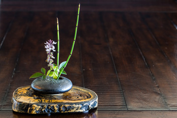 Ikebana flower arrangement on the wood.