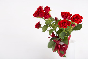 Bouquet of red roses in vase on white background