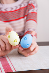 Fototapeta na wymiar Two colored easter eggs in female hands