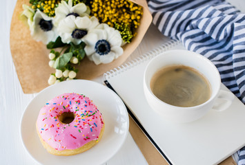 coffe and a donut with fresh flowers