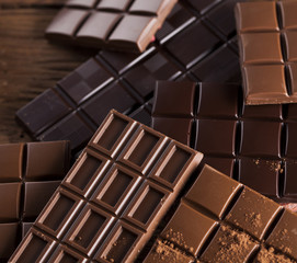 Dark homemade chocolate bars and cocoa pod on wooden