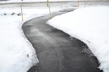 winding sidewalk after snow with snow removed