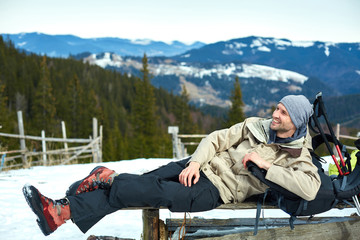 hiker have rest and drink tea on the trail in the Carpathians mountains at winter