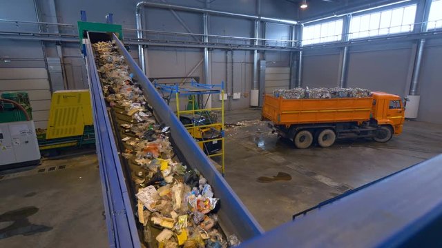 Plastic, cellophane trash on a conveyor at a recycling plant. No people. 4K.
