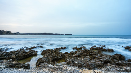 Fototapeta na wymiar blurred waves on a rocky sea coast