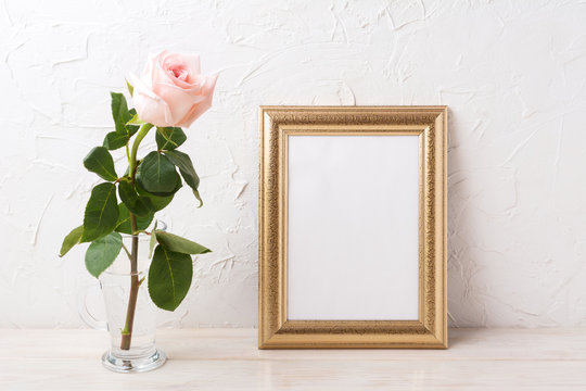 Gold frame mockup with tender pale pink rose in glass