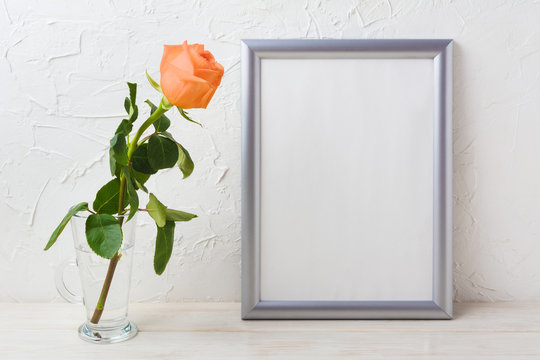 Silver frame mockup with orange-apricot rose in glass vase