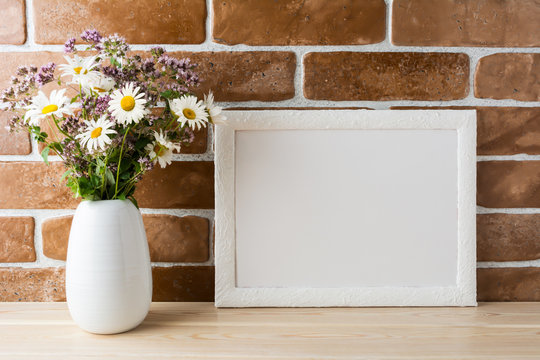 White landscape frame mockup with wildflowers bouquet in styled vase