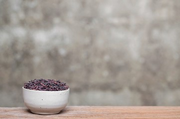 Close up of rice berry in bowl on wooden table