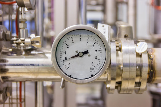 Closeup of pressure gauge, pressure gauge for monitor condition. Pipes and valves at pharmacy industry manufacture factory.