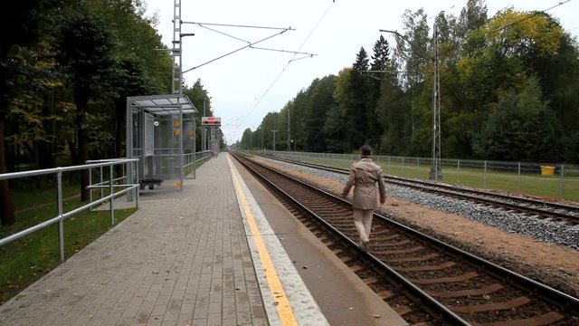 Man Walking Along Train Tracks. Man on railway tracks. Handsome businessman