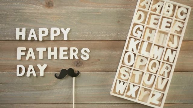 Unfinished wood letters sign Happy Father's Day on a painted wood background