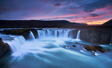 Stunning sunset over Godafoss Waterfall with smooth flowing in Iceland