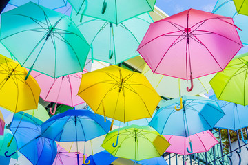 Hanging colorful umbrellas, on the street and blue sky.