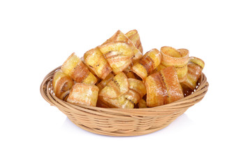 crispy banana chips with caramel in bamboo basket and on white background