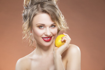 Obraz na płótnie Canvas Sensual Fruit Series. Portrait of Alluring Sexy Caucasian Blond Girl With Lemon. Posing Against Orange Background.