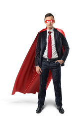 A businessman in a formal suit, a red flowing cape and a red eye mask with one hand in his pocket in front view.