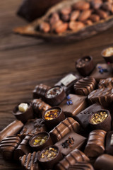 Chocolate bars and pralines on wooden background