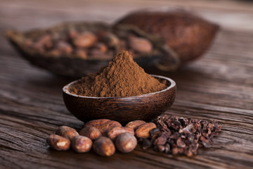 Cocoa beans in the dry cocoa pod fruit on wooden background