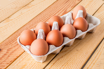 Eight Eggs in box on a wooden table.