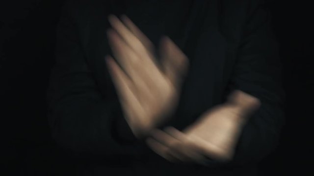 Caucasian male hands in long sleeve jacket apllauding and pull thumb up approuving sign gesture on black background, close up isolated