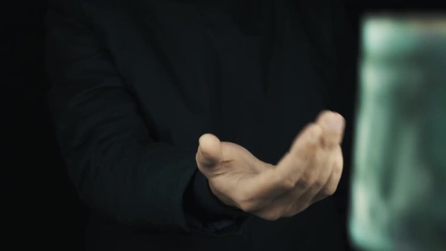 Caucasian male hand in long sleeve jacket making cash sign gesture rubbing fingers together, get ruble money and count it on black background, close up isolated