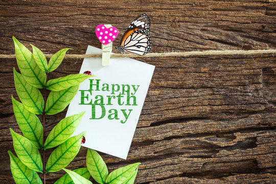  Happy Earth Day paper note hanging by red heart clips on wooden background