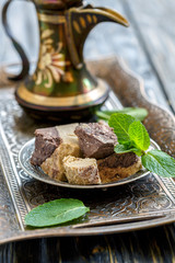 Plate with tahini halva with chocolate and jug.