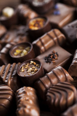 Chocolate bars and pralines on wooden background
