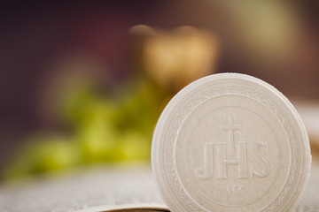Holy communion a golden chalice with grapes and bread wafers