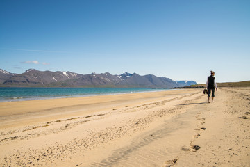 Fototapeta na wymiar Girl walking on a scenic sandy beach in ICeland during summer time