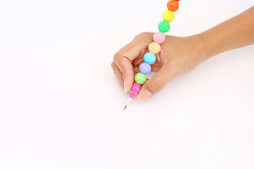 Hand holding colorful pencil on blank white paper background.