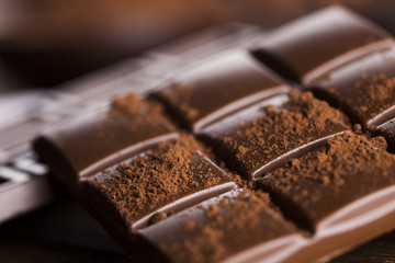 Dark homemade chocolate bars and cocoa pod on wooden