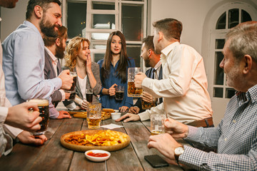 Group of friends enjoying evening drinks with beer