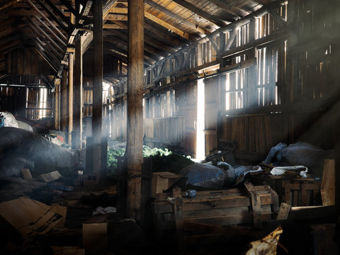 Old huge barn. A lot of garbage. Rays of light
