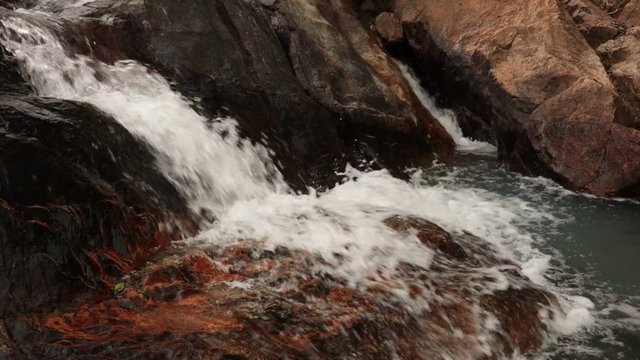Mountain river scene with cascading white water large boulders in a tropical asian climate high definition footage.