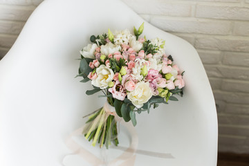 Obraz na płótnie Canvas Wedding bouquet with white and pink tulips and pink small roses on a chair 