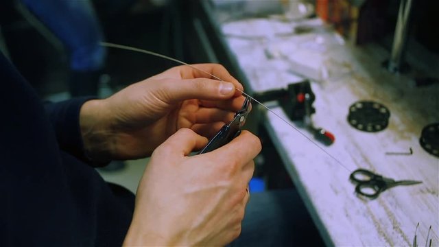 Male hands prepare wire for the electronic cigarette. After-sales service of the e-cigarette.