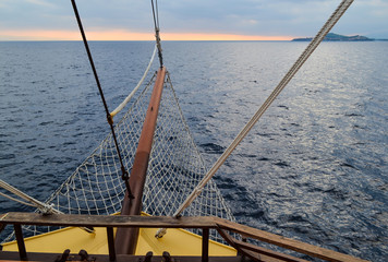 Sailing ship sails at storm. In front of the dark clouds.