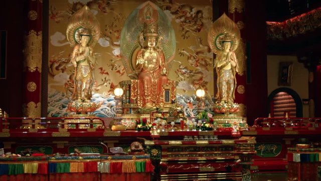 Buddha images stand over a colorful altar inside a temple in Singapore