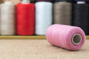 Pink spools of thread on sackcloth